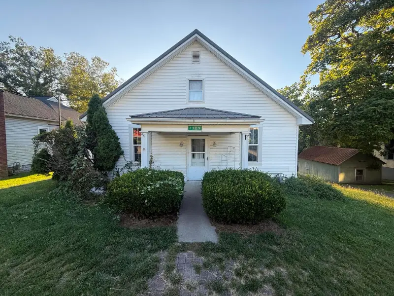 White one-and-a-half-story house with a covered front porch at 3329 Market Street, Rushville, Ohio