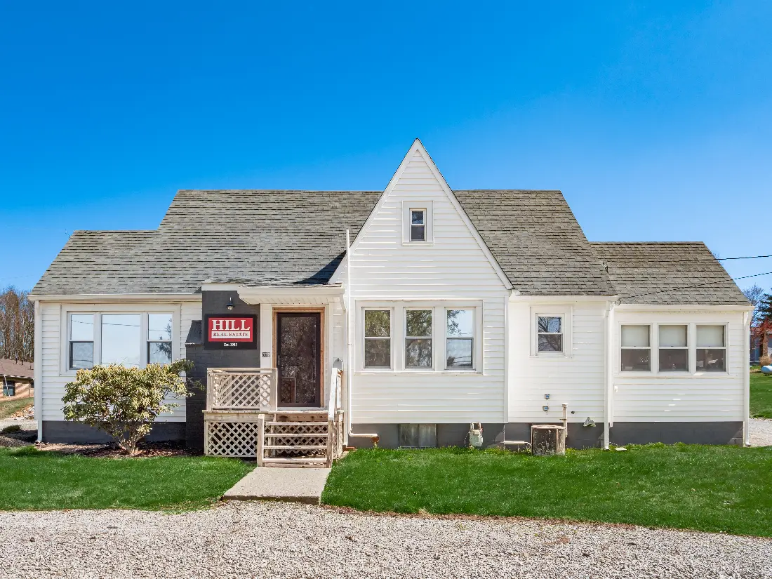 The Hill Real Estate Somerset office, a white Cape Cod style building with the Hill Real Estate Est. 1985 sign by the front door